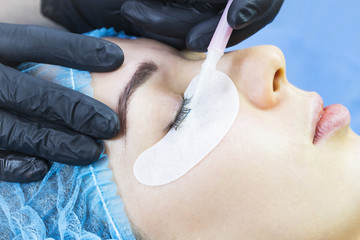 Woman on the procedure for eyelash extensions, eyelashes lamination. 