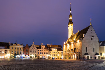 Naklejka na ściany i meble The Tallin gothic Town Hall building on the main old town square at night in Estonia capital city in winter. Tallinn is a popular travel destination in North Europe.