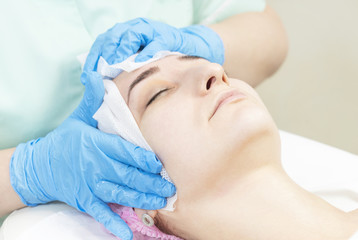 Fototapeta na wymiar Massage and facial peels at the salon using cosmetics 