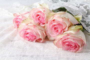 Beautiful pink roses lbouquet lying on a wooden table