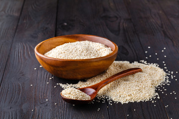 Sesam seeds in a little bowl on wooden table