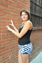 Female beauty expressions against a wall outside.