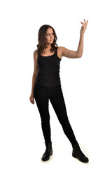 Obraz premium full length portrait of brunette girl wearing black singlet, jeans jeans and boots. standing pose, isolated on white studio background.
