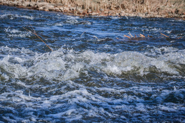 Splash of waves from a waterfall on a clear spring day