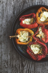 Colored peppers roasted with garlic, cheese  and herbs. Vegan food. Rustic style