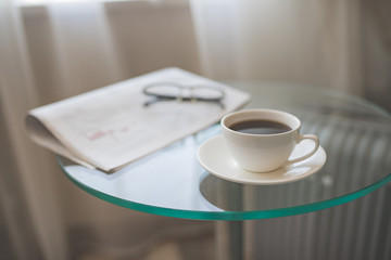 A cup of coffee with a newspaper