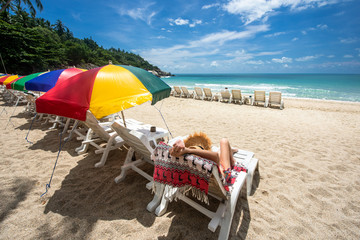 tourist woman cheerfully enjoy with the beach nature on the island by laying sitting on the deck couch beach with blue clear sky, summer time and vacation holidays occasion