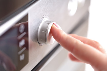 Naklejka premium Detail of female hand while using the microwave
