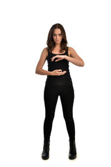 full length portrait of brunette girl wearing black singlet, jeans jeans and boots. standing pose, isolated on white studio background.