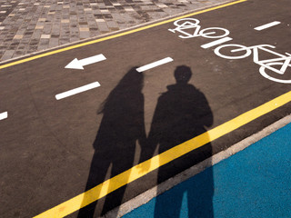 White bicycle sign with arrow on the asphalt, bike road sign on the street, bicycle lane sign on street, gray background