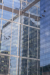 Fototapeta na wymiar Industrial climbers wash the facade of modern high-rise building