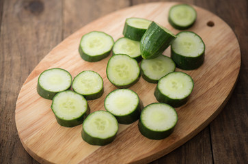 Cucumber on wooden plate and vintage background

