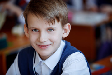 Cute little boy in school uniform looking at the camera