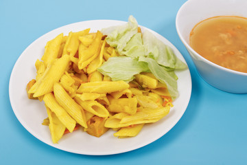 Baked pasta with curry on a blue