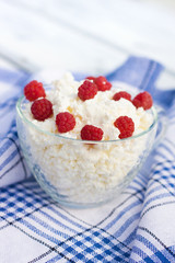 Milk and glass bowl with soft cheese and raspberry in summer