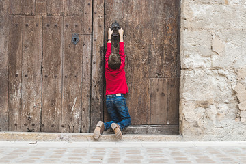 Child knocking on an old door