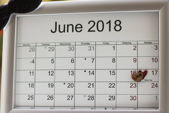 Close-up: calendar of the month June 2018 is on a grey frame and decorated a moustache and two symbols of heart on the date of Father’s day.