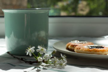Mint cup, pancakes and flower on the table