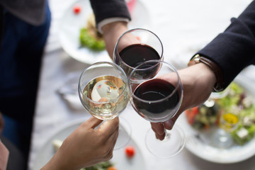 Business people celebrate agreement signing at restarant. Clang glasses.