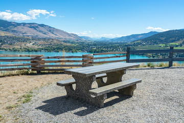 Table with benches on picnic area with great view on Kalamaka lake and Rocky mountain in Canada