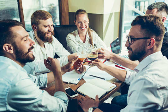 Young cheerful people smile and gesture while relaxing in pub.