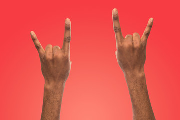 Black male hands making rock-n-roll gesture
