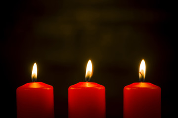 Lit red candles on a dark background