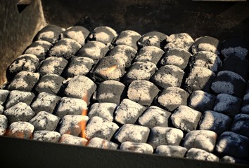 Outdoors and barbecue concept: fire when lighting charcoal briquettes in a barbecue.