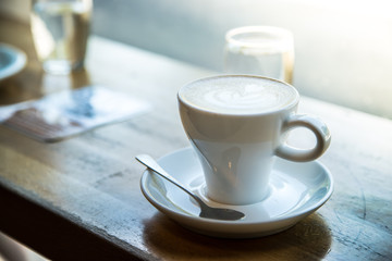 Kaffeetasse (Cappucino) mit Wasserglas auf Holztisch, Konzept 