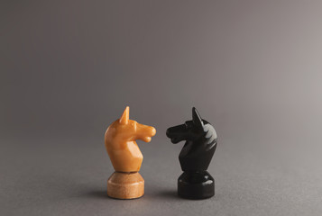 Confrontation of chess pieces on gray background