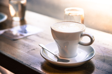 Kaffeetasse (Cappucino) mit Wasserglas auf Holztisch, Konzept 