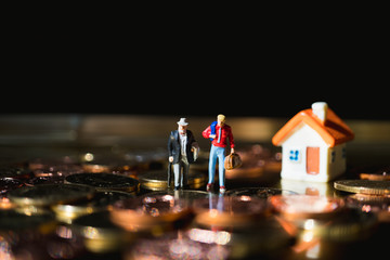 Miniature people, employer and employee standing with golden stack coins using as business concept