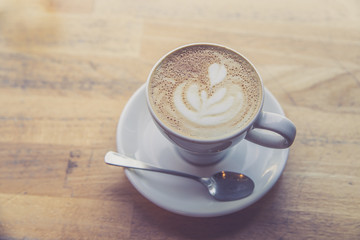 Kaffeetasse mit Cappucino auf Holztisch, Morgen