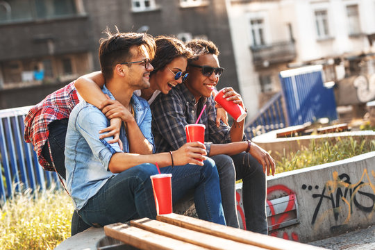 Group of friends hangout  at the street.They embrace each other and drinking cold juice.Fast food.