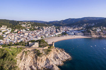 Fototapeta na wymiar Aerial view of picturesque rocky landscape with fortified walls and residential buildings of Tossa de Mar, Spain