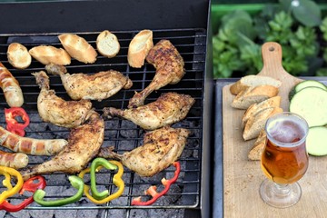 Tasty food, nutrition, culinary and barbecue concept: grilled sausages,chicken thigh and vegetables on a barbeque.