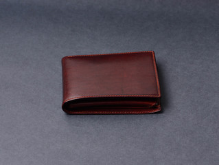 Brown leather wallet on gray texture