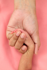 Newborn holding parents hand-care and protection