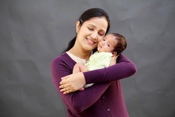 Cheerful mother holding newborn baby - 205913254