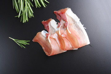 prosciutto, jamon on a black background
