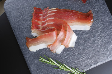 prosciutto, jamon on a stone background