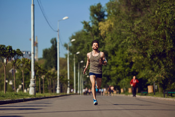 A young male runner jogs in the park.