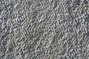 a background of textured concrete with brightly colored shades of light and shadow