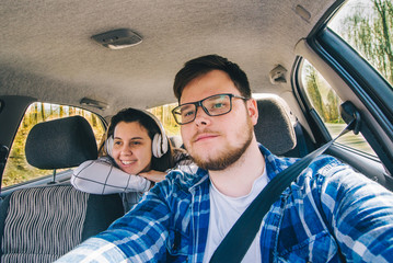 man driving car. woman sitting as passenger at backseats. car tr