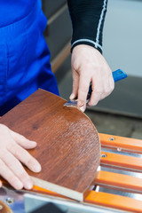 A professional carpenter processes the plastic edges of the countertop with a knife-edge cut. The concept of furniture production.