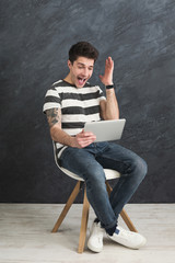 Handsome man using laptop in studio