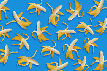 banana pattern. opened yellow bananas on blue paper background, trendy flat lay. summer concept