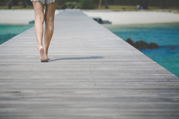 Travel woman foot on wooden bridge