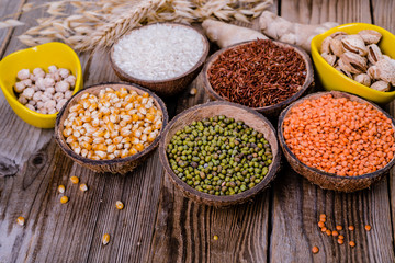 Different   grains, seeds, beans  in bowls  on wooden table