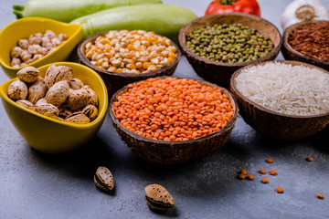 Different   grains, seeds, beans  in ceramic bowls  on grey concrete table